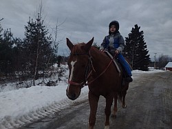 Arthur, le garçon de Laurence, la propriétaire d’Équitation sur mesure, et son cheval Ready To Go, sur le départ d'une petite balade familiale.